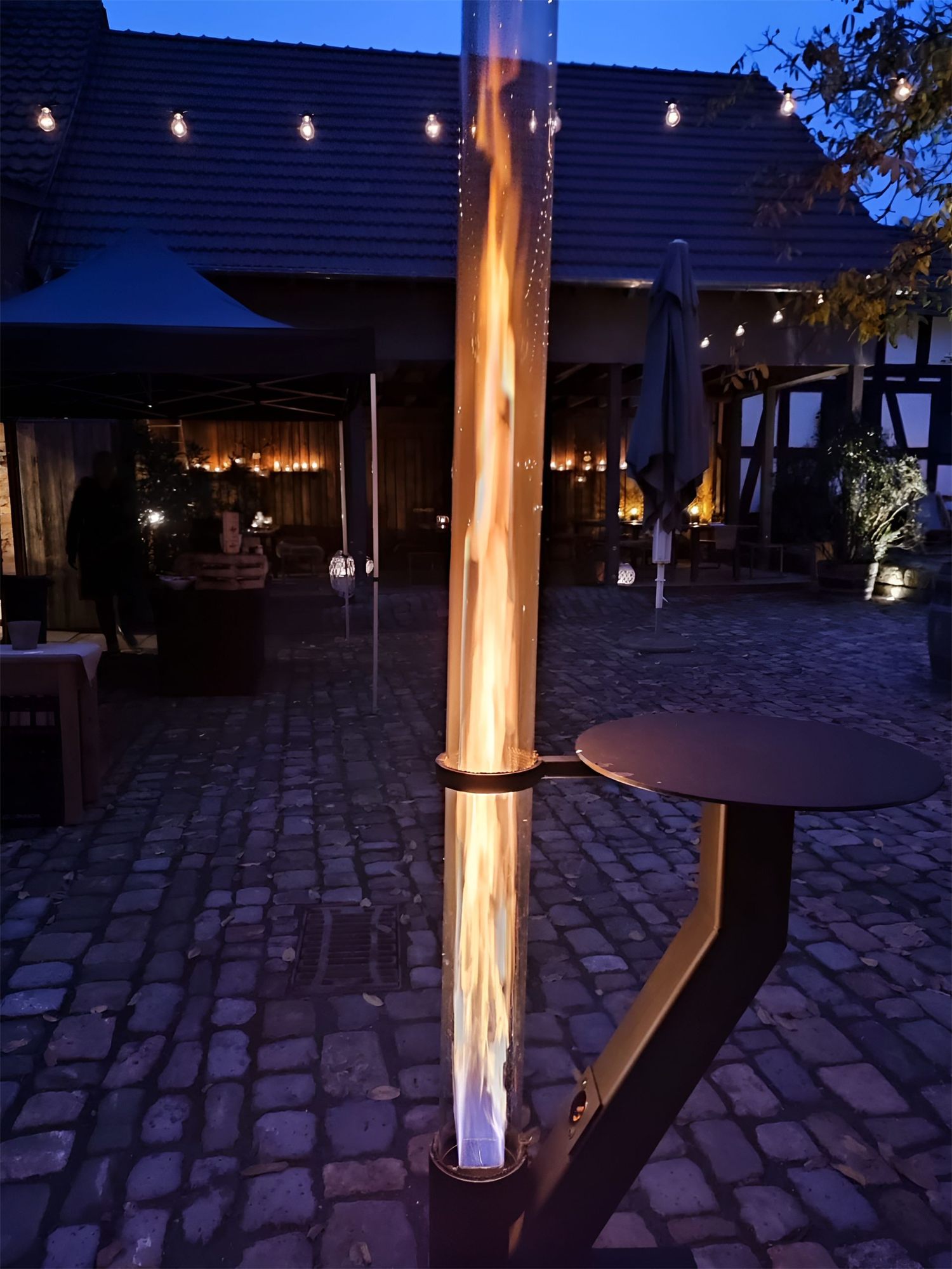 Die Rhönfackel brennt am Abend auf einer Terrasse