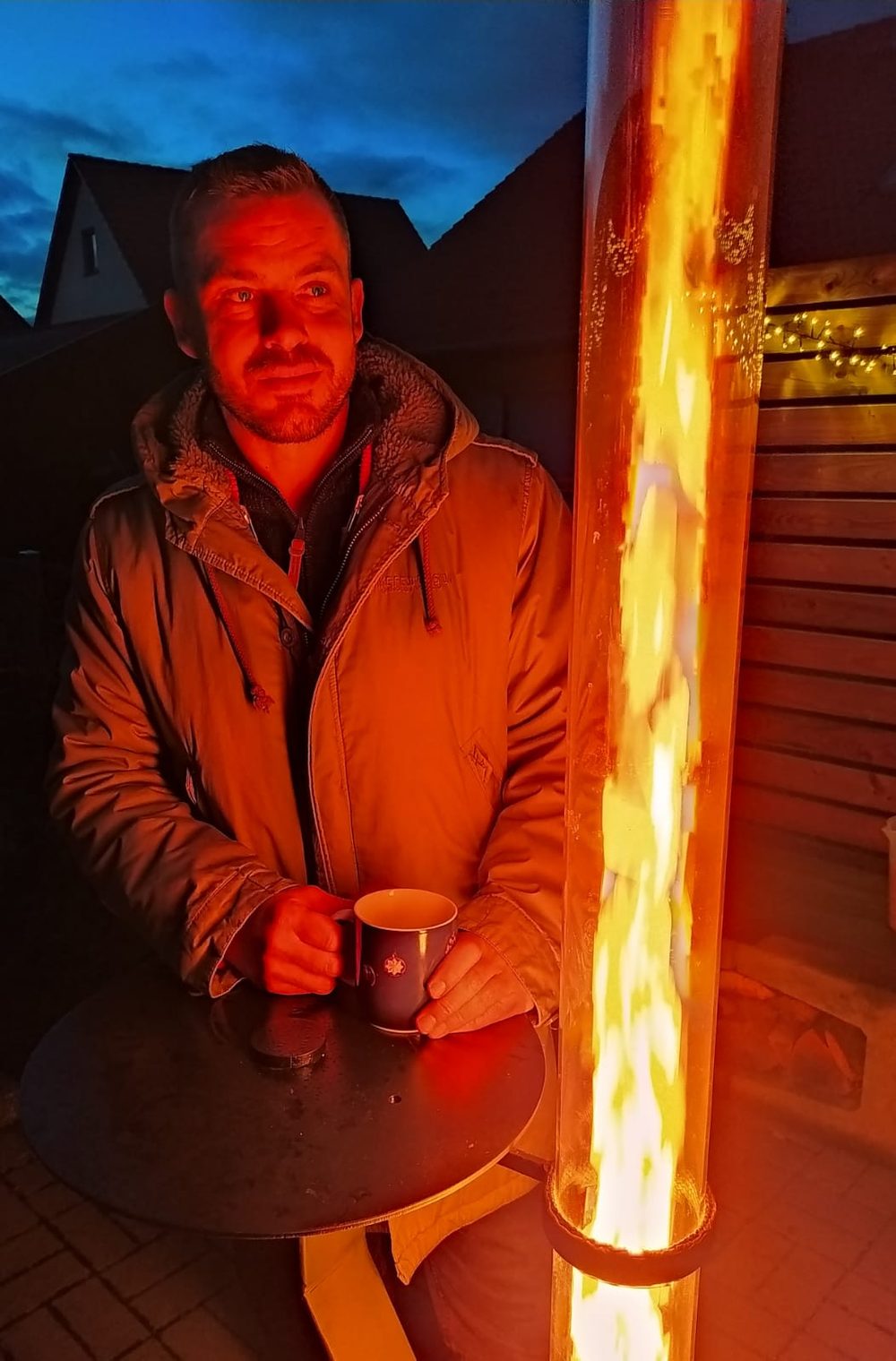 Abends mit einer Tasse an der brennenden Rhönfackel auf der Terrasse